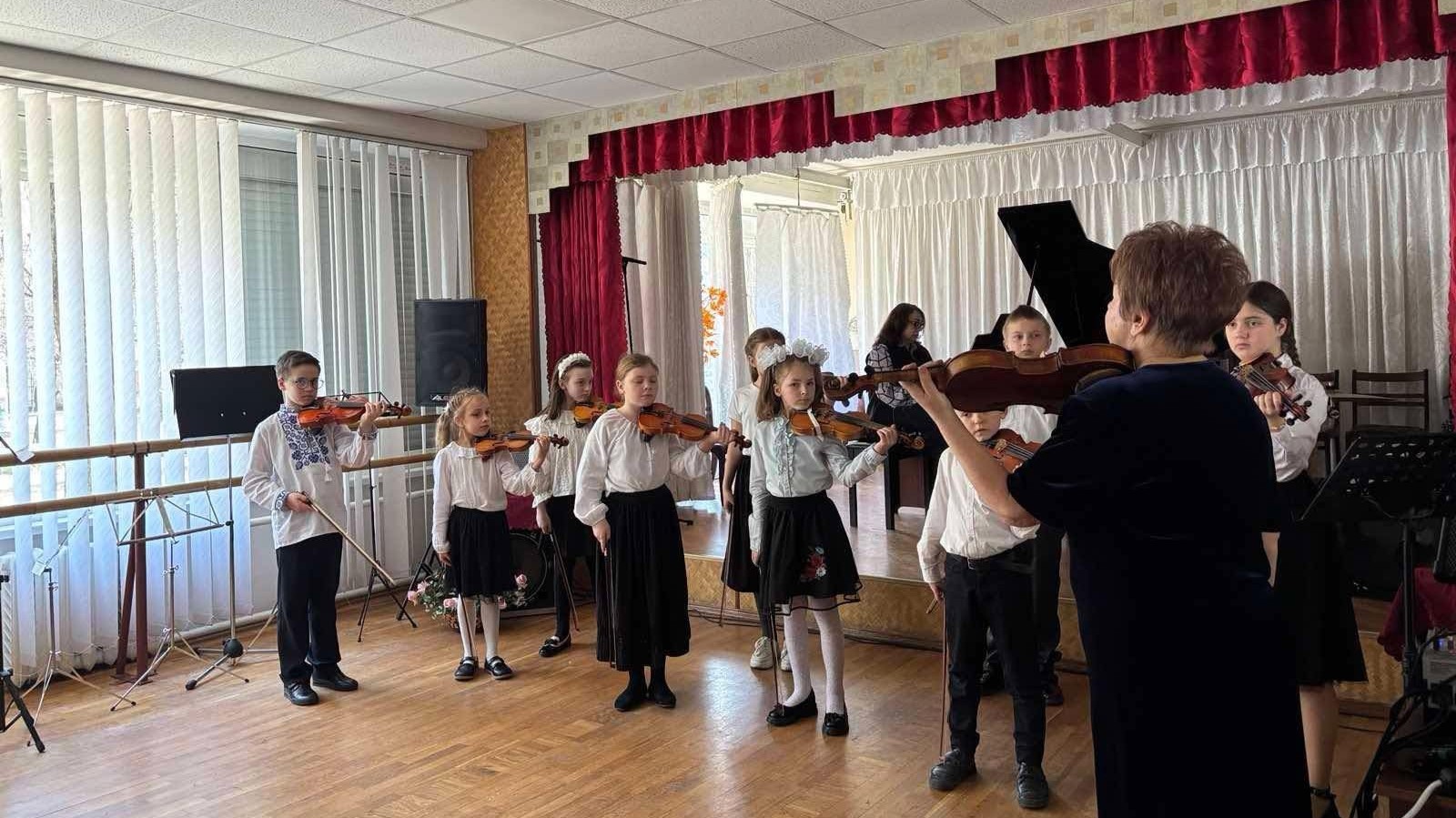 Молодші учні зі скрипками займаються з педагогом
