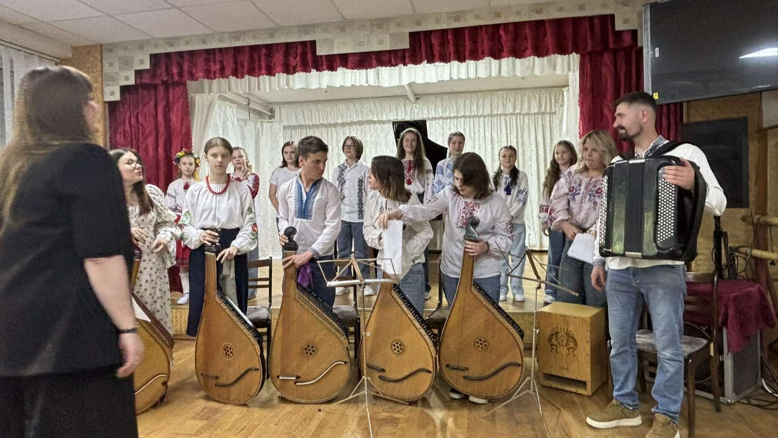 Ансамбль бандуристів у вишиванках та акордеоніст на сцені