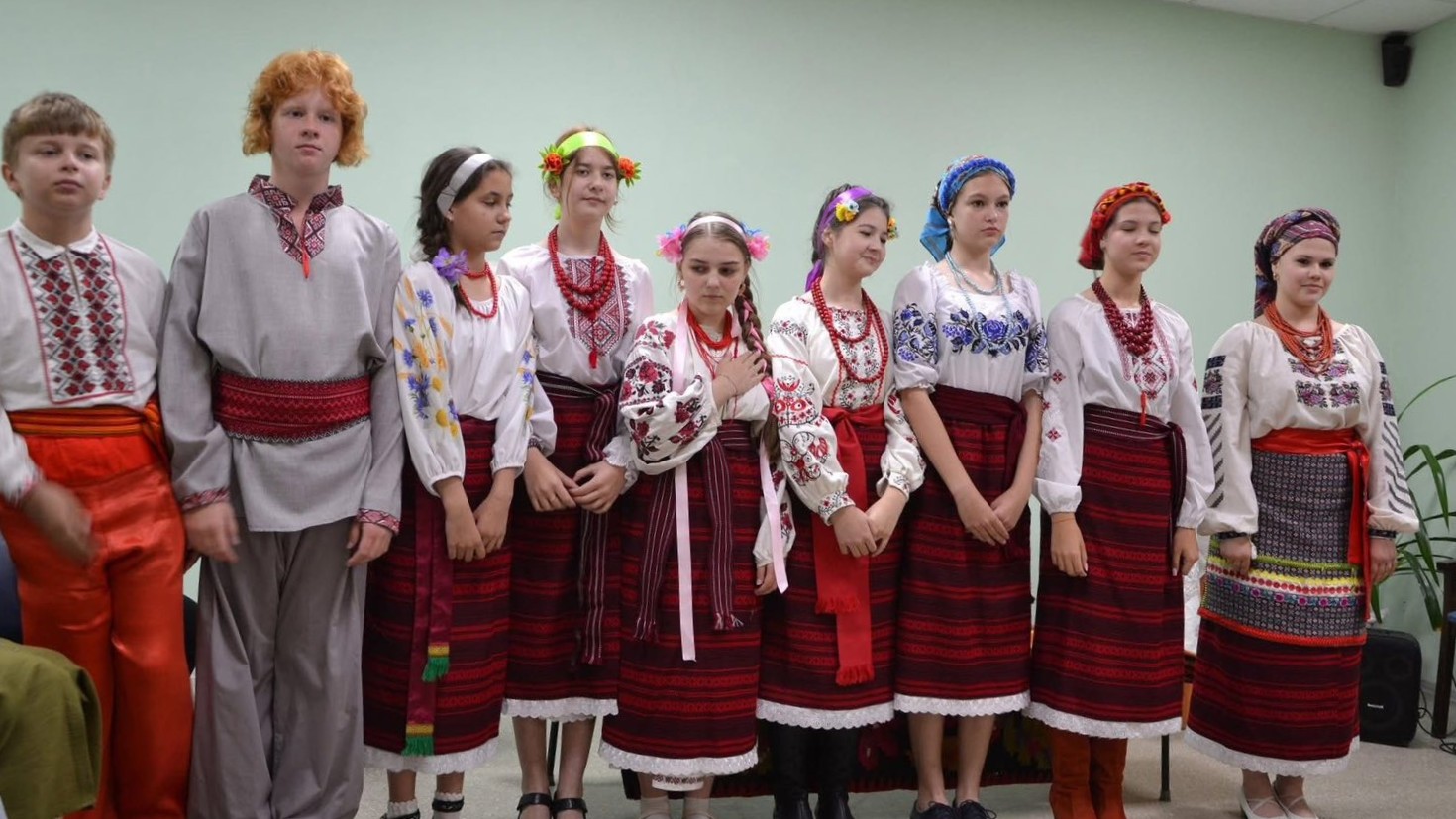 Підлітки у традиційних українських костюмах стоять разом